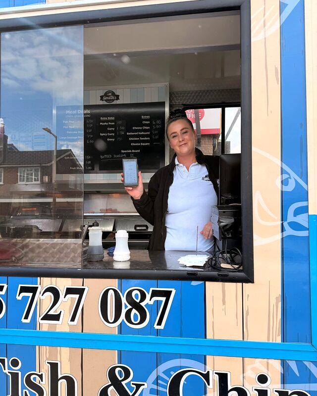 Fish and chip van server in Sheffield holding a Shift4 card machine