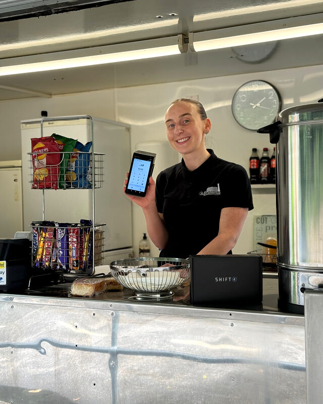 Mobile catering van owner in Mansfield holding a Shift4 card machine
